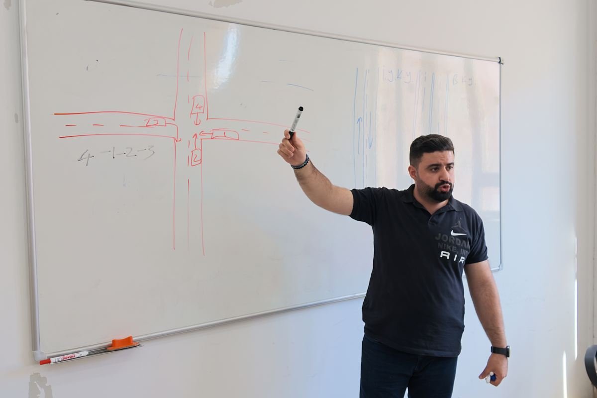 Eğitmenimiz derslikte tahtada kavşak kurallarını anlatırken